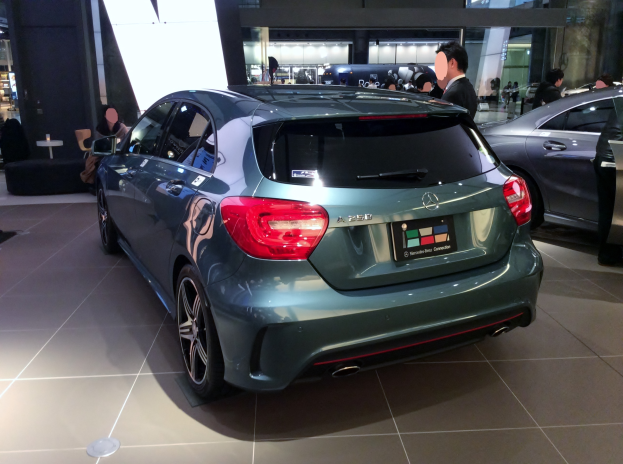 Ein Mercedes-Benz A-Klasse Schrägheck auf der Internationalen Automobil-Ausstellung in Frankfurt, ein elegantes, modernes Design mit glänzender schwarzer Lackierung und Chromakzenten, umgeben von einer Gruppe von Menschen.