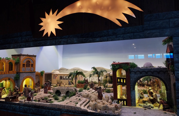 Eine Krippenausstellung im Museum, mit Figuren, Tieren, Gebäuden und Grünpflanzen, beleuchtet von oben.