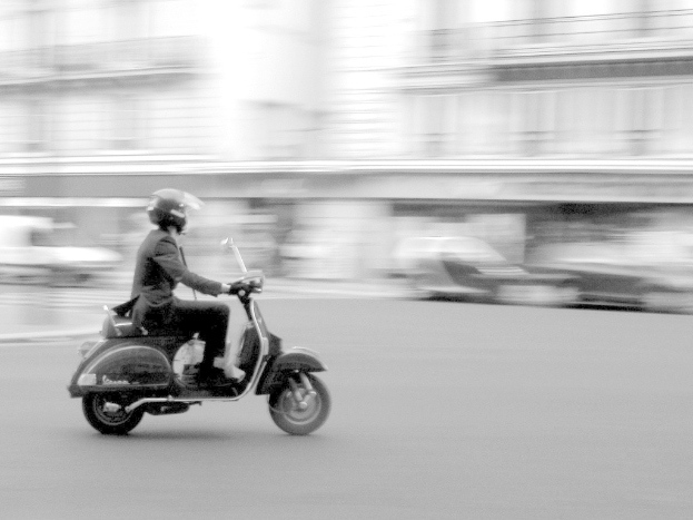 Eine Person fährt einen Roller auf der Straße.