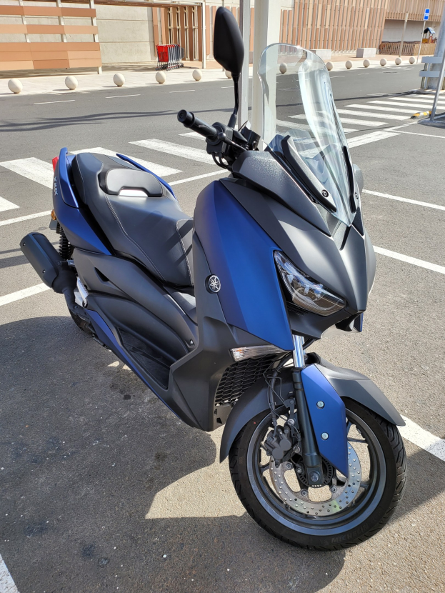 Blaue Yamaha YZF-R15 V3.0-Motorrad in einer Parklücke neben einem Gebäude mit einem Geländer auf der linken Seite geparkt.