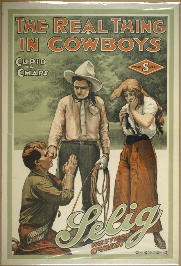 Plakat an einer Wand mit drei Personen, zwei Männer mit Cowboyhüten und eine Frau in einem langen Kleid, mit der Aufschrift "The Real Thing in Cowboys" darüber auf einem hellgelben Hintergrund.