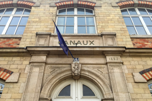 Ein Gebäude mit Glasfenstern und einer Tür, eine Flagge davor und ein Text, der darauf hinweist, dass es ein Hotel ist.