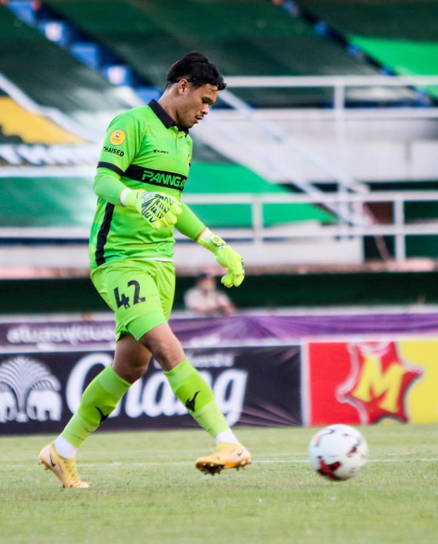 Ein Mann in einem grünen Torwarttrikot schießt einen Fußball auf einem Rasenfeld in einem Stadion. Im Hintergrund sind Banner mit der Aufschrift "Chivas USA vs Mexico City, 3-1, Copa Libertadores" zu sehen.