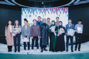 Gruppe von Menschen auf einer Bühne mit Blumensträußen und Urkunden, vor einem 'Youth Solar Awards 2019'-Plakat.