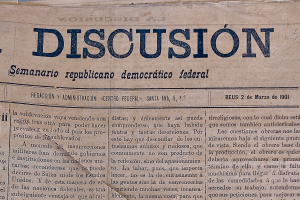 Eine gelbliche, leicht zerknitterte Zeitung mit der Aufschrift "Diskussion" in schwarzer Tinte, die die Schlagzeile "Semanario Republicano Democrático Federal" trägt.