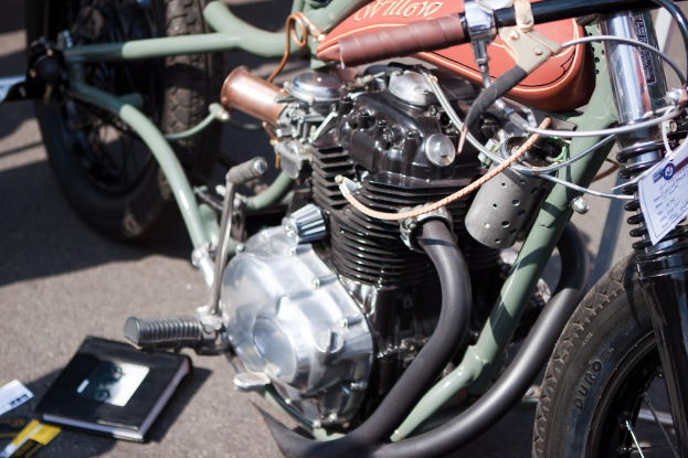 Motorräder und ein aufgeschlagenes Buch auf einer Fläche.