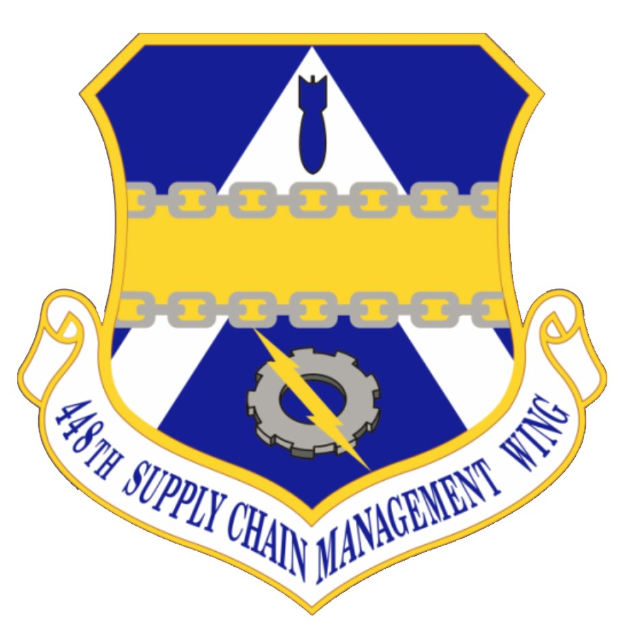 Logo des 48. Versorgungsgeschwader mit einem blauen Schild, einem weißen Stern und einer Banner, umrandet von Weiß mit schwarzer Schrift.
