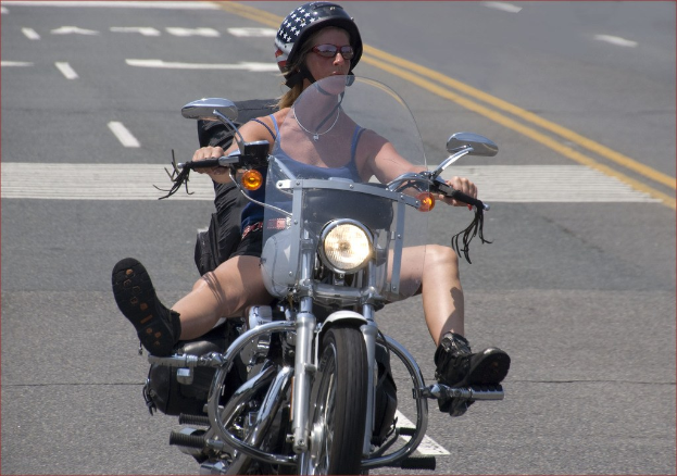 Frau auf Fahrrad auf Straße mit schwarzem Helm