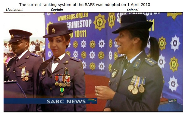 Gruppe von Menschen in Uniformen und Hüten mit einem Banner, das Text über das am 1. April 2010 eingeführte SAP-Ranking-System enthält.