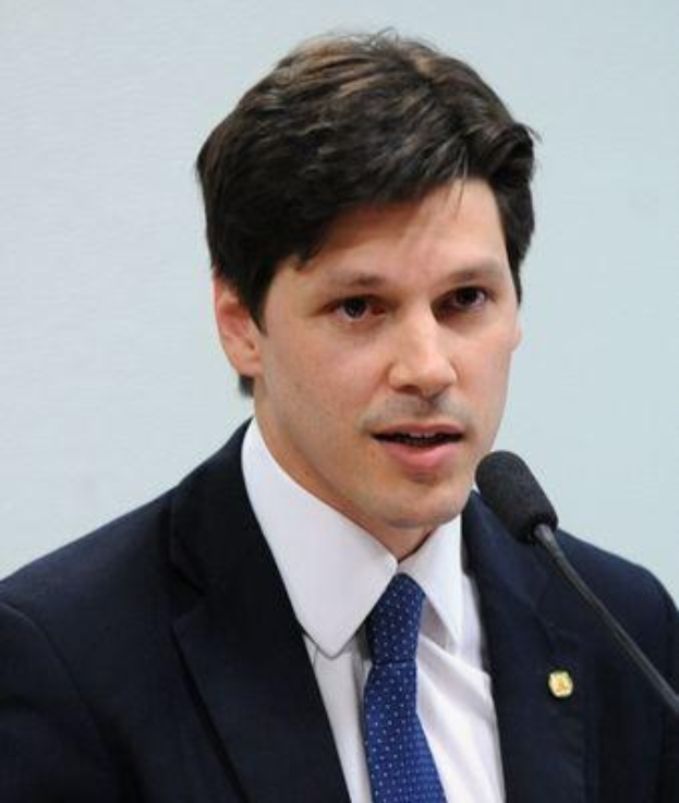 Ein Mann in Anzug und Krawatte spricht in ein Mikrofon an einem Podium, wahrscheinlich um ein Regierungsgesetz zur Verbots des Internetsetz zu unterstützen.