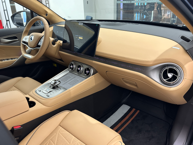 Das Innere eines Mercedes-Benz S-Klasse Limousinen auf der IAA in Frankfurt, mit Lenkrad, Armaturenbrett, Bildschirmen, Knöpfen, Sitzen, Außenspiegeln und Glasfenstern, durch die Menschen, Gebäude und andere Objekte im Hintergrund zu sehen sind.