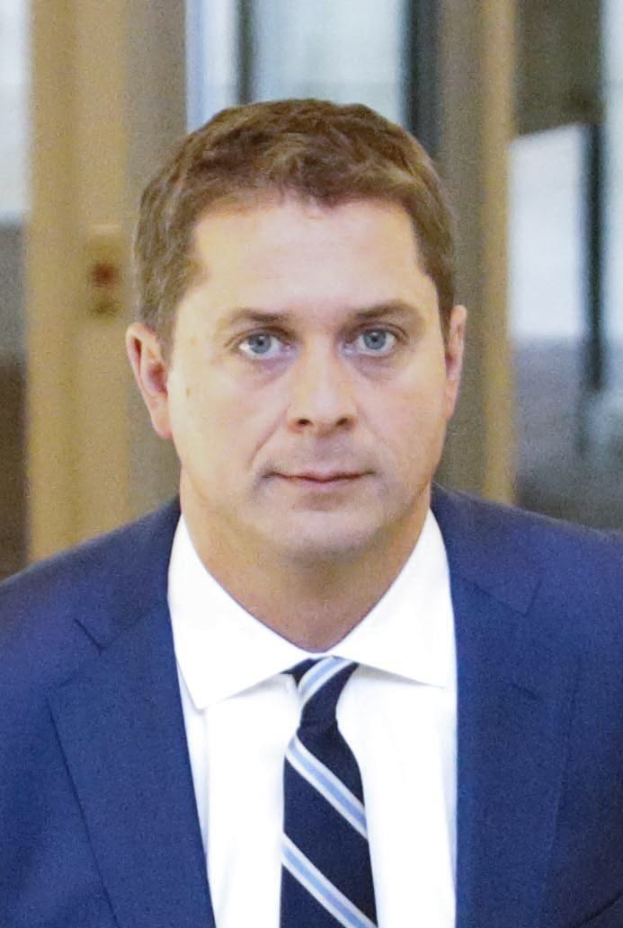 Ein Mann in Anzug und Krawatte geht einen Flur entlang mit einem unscharfen Hintergrund, der besorgt wirkt.