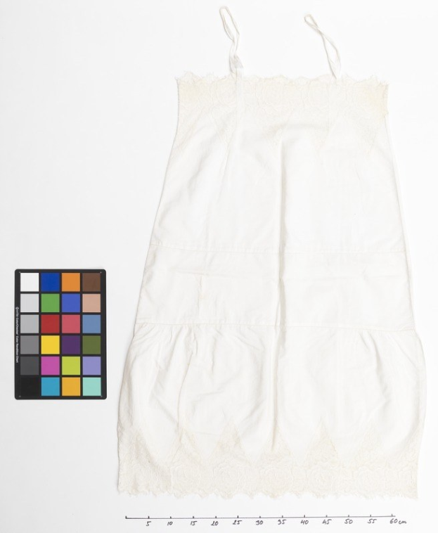 Weißes Slipkleid mit weißer Spitze an einem weißen Hintergrund, begleitet von einem Farbpalettenfeld links und Text unten.