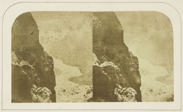 Schwarz-weiß-Foto einer felsigen Klippe mit Felsen im Vordergrund und Himmel im Hintergrund, mit Text unten.